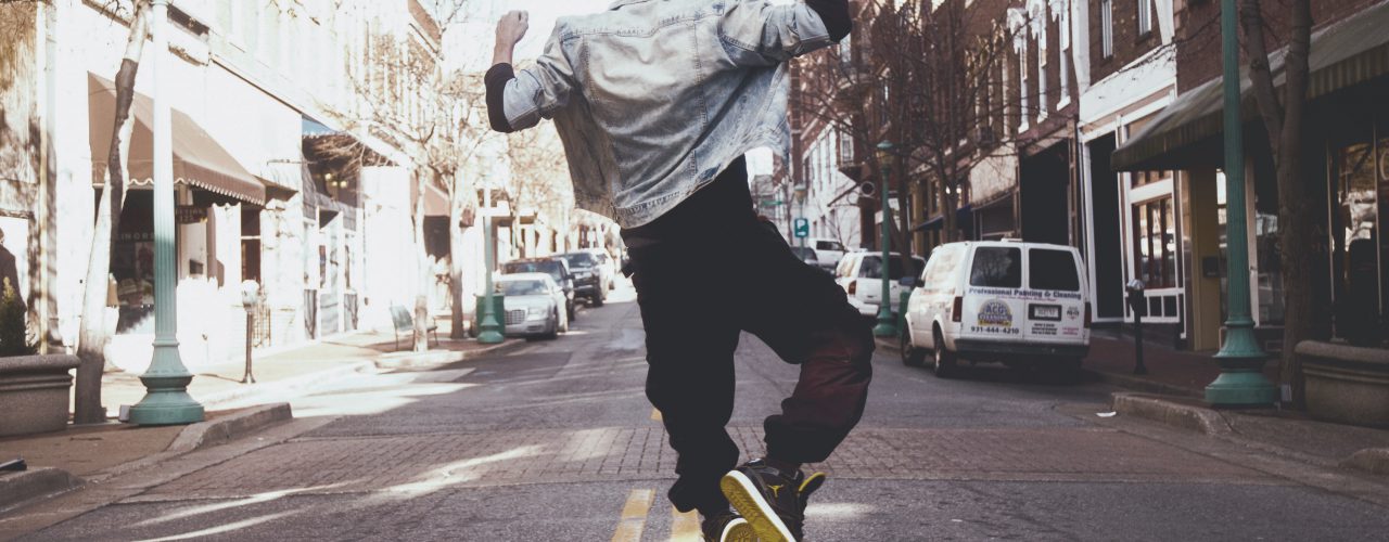 Guy jumping up in middle of city street