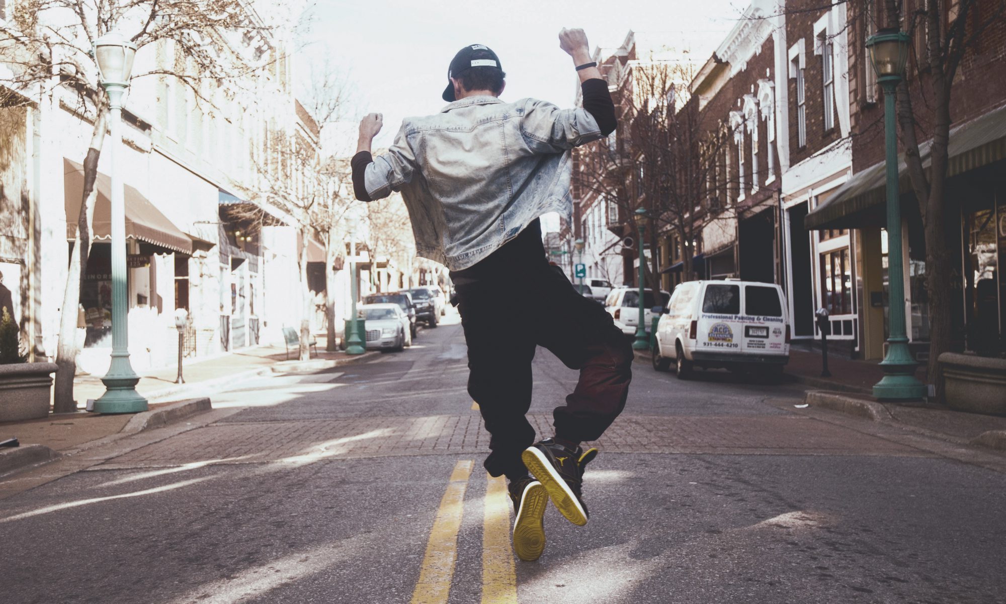 Guy jumping up in middle of city street