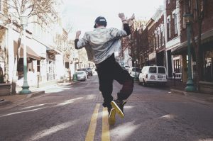 Guy jumping up in middle of city street