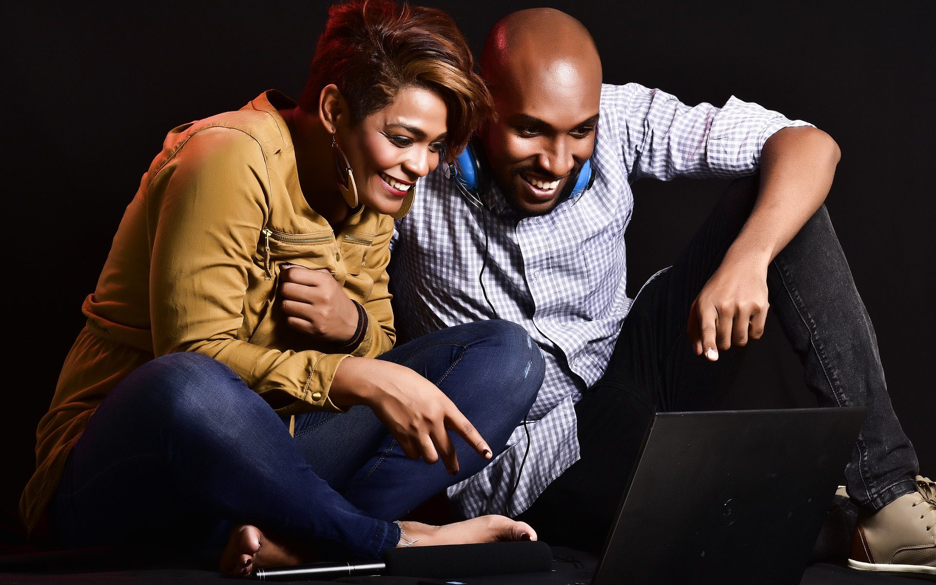 woman and man sitting in front of computer smiling