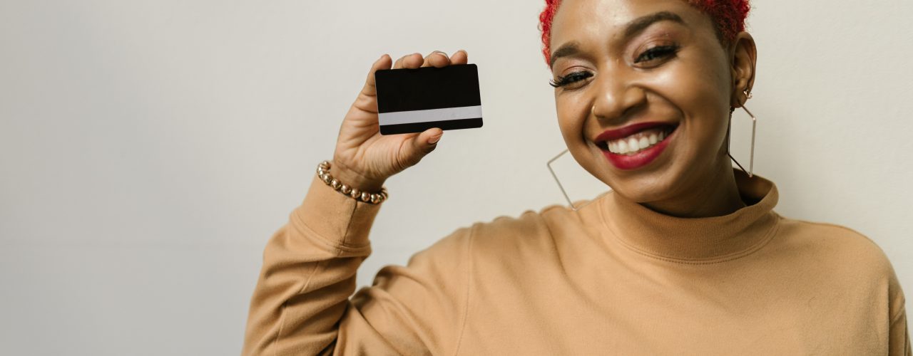 A woman holding up a blank credit card.