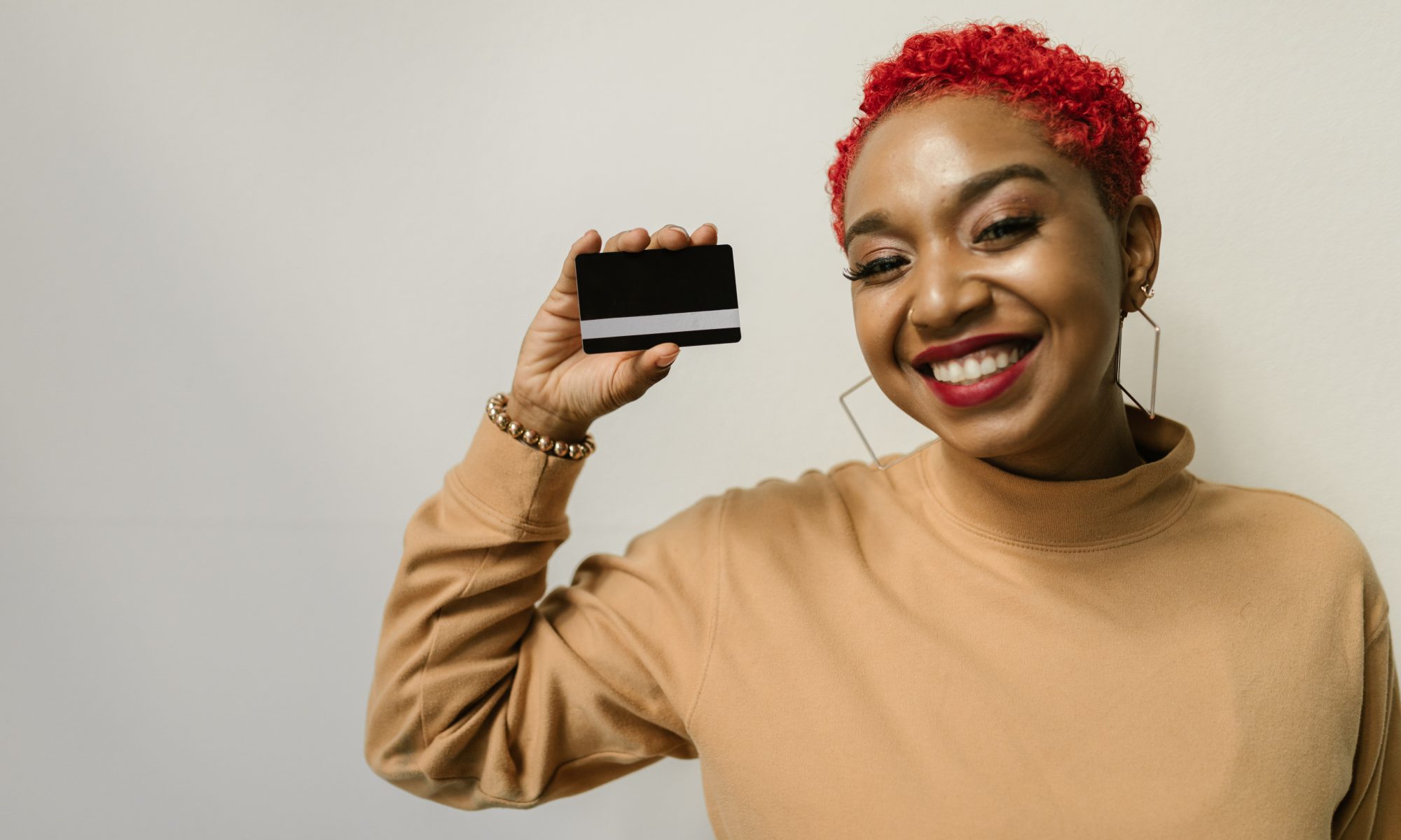 A woman holding up a blank credit card.