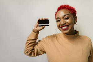 A woman holding up a blank credit card.