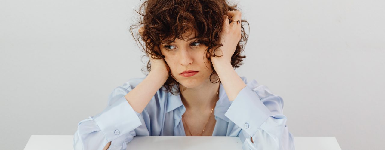 A stressed woman with a dollar infront of her.