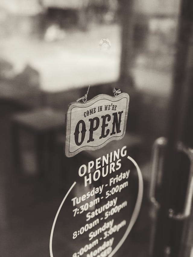 An sign on a business window. The sign says the business is open.