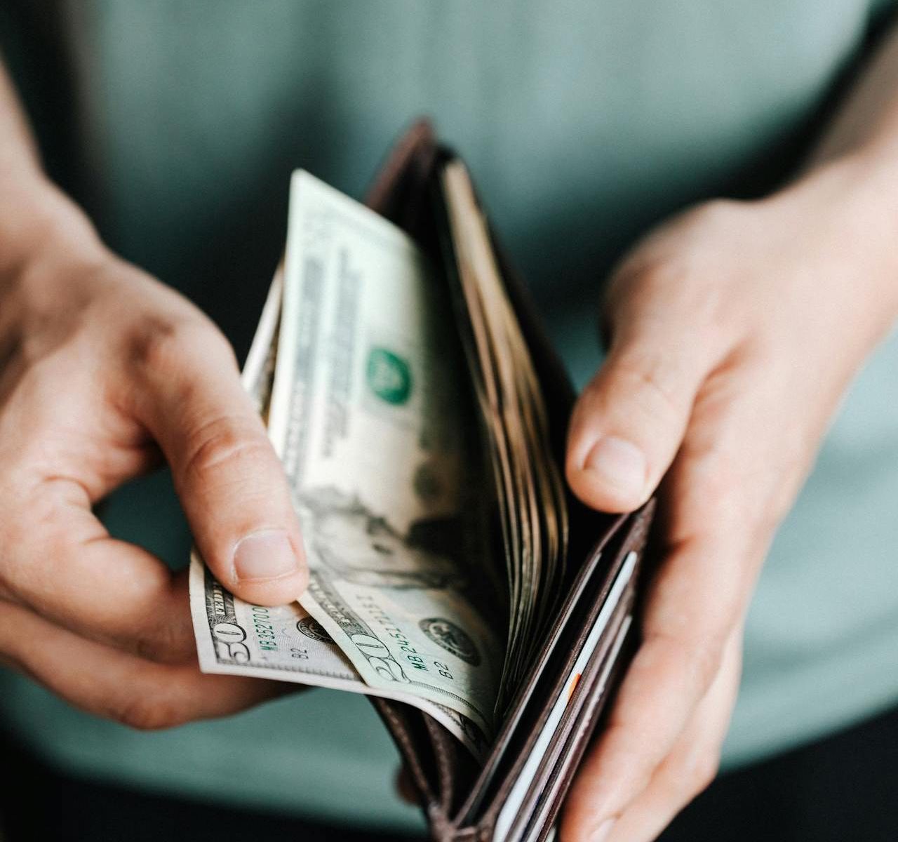 A person looking at money in their wallet.
