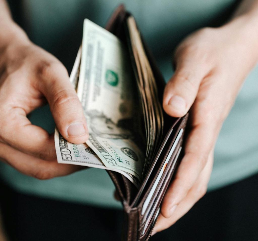 A person looking at money in their wallet.