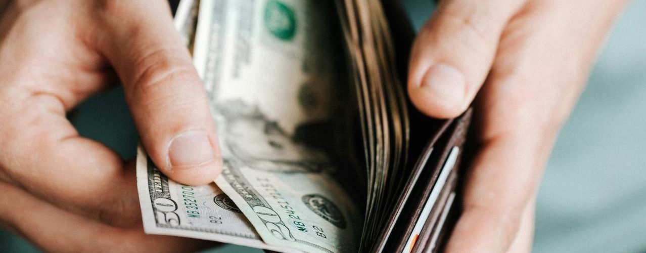 A person looking at money in their wallet.